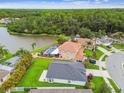 An aerial view showcases a property with a pool, backing onto a serene lake and lush green trees at 630 Lake Cypress Cir, Oldsmar, FL 34677