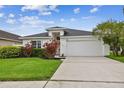 Charming single-Gathering home with well-maintained lawn and landscaped front yard, featuring a two-car garage at 630 Lake Cypress Cir, Oldsmar, FL 34677