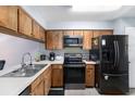 Efficient kitchen featuring wood cabinets and modern black appliances at 6346 Bonnie Bay N Cir, Pinellas Park, FL 33781