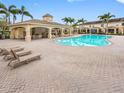 Community pool area with poolside seating and covered lounging space surrounded by palm trees at 6706 47Th N St, Pinellas Park, FL 33781