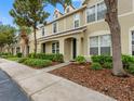 Charming townhouse featuring manicured landscaping and a welcoming entryway with decorative trees at 6706 47Th N St, Pinellas Park, FL 33781