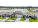 Aerial view of a two-story home with a light-blue facade and a pond in the backyard at 8576 Broadstone Dr, Wesley Chapel, FL 33544