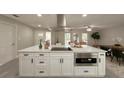Bright kitchen with a white center island, stainless steel appliances, and sleek black hardware at 939 Woodland Dr, Palm Harbor, FL 34683