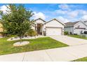 Single-story house featuring a well-maintained lawn, a driveway leading to a two-car garage, and tasteful landscaping at 944 Old Windsor Way, Spring Hill, FL 34609