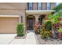 Close-up view of a front entrance with an arched portico, plants and shrubs at 10512 Scenic Hollow Dr, Riverview, FL 33578