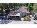 An exterior view of the home featuring a covered porch and vibrant landscaping at 14210 Downing St, Dover, FL 33527