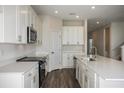 Modern kitchen featuring white cabinets, stainless steel appliances, and sleek countertops at 14411 Meadow Bird Ave, Riverview, FL 33579