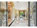 Elegant foyer with marble flooring, decorative columns, and views of the pool area at 16248 Ivy Lake Dr, Odessa, FL 33556