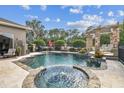 Beautiful backyard with a luxurious pool, spa, and stone patio, ideal for outdoor entertaining at 16248 Ivy Lake Dr, Odessa, FL 33556