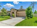 Attractive home showcasing a tidy lawn, stone accents, and a convenient two-car garage at 18596 Rococo Rd, Spring Hill, FL 34610