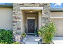Inviting front entryway features a stone accent wall, covered porch, and a decorative front door at 18596 Rococo Rd, Spring Hill, FL 34610