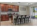 Modern kitchen with stainless steel appliances, granite countertops, an island with seating, and a tile backsplash at 18596 Rococo Rd, Spring Hill, FL 34610