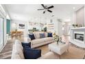 Bright, open-concept living room with hardwood floors, fireplace, modern furnishings, and seamless flow into dining and kitchen areas at 18712 Forest Glen Ct, Tampa, FL 33647