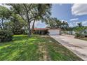 Charming single-story home with a large front yard, mature trees, and a brick facade at 1899 Oak Park S Dr, Clearwater, FL 33764