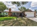 Charming brick home with a well-manicured lawn, gated entry, and attached two-car garage at 1899 Oak Park S Dr, Clearwater, FL 33764