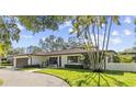 Charming one-story home boasts a manicured lawn and lush landscaping at 208 Live Oak Ln, Largo, FL 33770