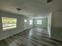 Bright living room with new gray flooring, neutral walls, and lots of natural light at 21352 Lehouier Dr, Brooksville, FL 34601