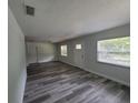Open living area with gray floors, white trim, and plenty of natural light at 21352 Lehouier Dr, Brooksville, FL 34601