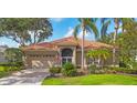 Charming single-story home with a tile roof, lush landscaping, and a two-car garage at 2518 Dick Wilson Dr, Sarasota, FL 34240