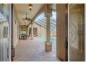 Covered patio with brick flooring leading to a screened-in pool and spa at 2518 Dick Wilson Dr, Sarasota, FL 34240