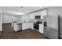 Open kitchen with stainless steel appliances, granite countertops, and hardwood floors at 29563 Fedora Cir, Brooksville, FL 34602