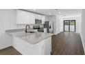 A kitchen area featuring granite countertops, stainless steel appliances and sliding glass door access at 29563 Fedora Cir, Brooksville, FL 34602