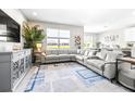 Spacious living room featuring a large sectional sofa, stylish rug, and ample natural light at 30762 Parrot Reef Ct, Wesley Chapel, FL 33545