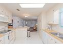 Open kitchen featuring white cabinets, appliances, and bar seating, with a view into the living room at 3301 Alt 19 # 819, Palm Harbor, FL 34683