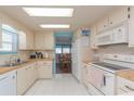 Well-lit kitchen with wooden countertops, white cabinets, and a view of the adjacent dining area at 3301 Alt 19 # 819, Palm Harbor, FL 34683