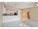 Open-concept kitchen and living area with bar seating, white cabinets and black appliances at 3389 Crystal E Ct # J, Palm Harbor, FL 34685