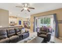 Open concept living room featuring tile floors and access to the kitchen and outdoor seating at 34447 Windknob Ct, Wesley Chapel, FL 33545