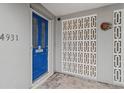 Bright blue front door with mid-century modern details, white brick, and decorative sun adding to the home's curb appeal at 4931 Pelican Dr, New Port Richey, FL 34652