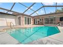 Enclosed swimming pool featuring a screen enclosure, clear blue water, and plenty of sunlight for outdoor relaxation at 4931 Pelican Dr, New Port Richey, FL 34652