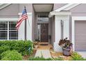 Inviting front entrance with American flag, well-kept landscaping and a brown front door at 5013 119Th E Ter, Parrish, FL 34219