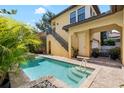 Backyard pool with stone trim and tropical plants surrounded by a backyard patio with stairs at 6113 Yeats Manor Dr, Tampa, FL 33616