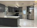 Modern kitchen featuring stainless steel appliances, gray cabinetry, and marble countertops at 6820 26Th W St, Bradenton, FL 34207