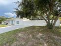Charming single-story home with a well-manicured lawn, mature tree, and white fence at 7536 38Th N Ave, St Petersburg, FL 33710