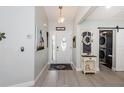 Inviting foyer with light walls and flooring, decorative rug, stylish decor, and convenient laundry area with sliding door at 7547 Landmark Dr, Spring Hill, FL 34606