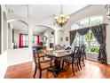Elegant dining room boasts a large table, chandelier, and an arched window with decorative curtains at 8814 N River Rd, Tampa, FL 33635