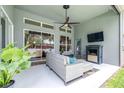 Relaxing covered patio features a ceiling fan, outdoor fireplace, and comfortable seating area at 8814 N River Rd, Tampa, FL 33635