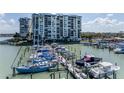 Beautiful condo building overlooking a marina filled with boats on a sunny day at 9525 Blind Pass Rd # 505, St Pete Beach, FL 33706