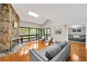 Bright living room featuring a stone fireplace, skylight, and sliding glass doors to the balcony at 1111 N Bayshore Blvd # E10, Clearwater, FL 33759