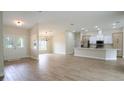 Spacious living room featuring wood-look tile flooring, neutral paint, and modern lighting at 11483 Poorwill Ave, Brooksville, FL 34614