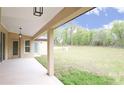 Covered patio with ample space for outdoor seating overlooking the expansive backyard at 11483 Poorwill Ave, Brooksville, FL 34614