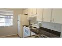 Well-lit kitchen featuring white cabinets, a stove, and a refrigerator at 11511 113Th St # 4F, Seminole, FL 33778