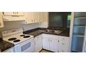 Functional kitchen features white cabinets and a sink with granite countertops at 11511 113Th St # 4F, Seminole, FL 33778