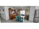 Bright dining room featuring vintage cabinet, stainless refrigerator, and seating for four at 123 S Dolphin Dr, Oldsmar, FL 34677