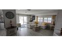 Cozy living room featuring white wood floors, a comfortable white sofa, and ample natural light at 123 S Dolphin Dr, Oldsmar, FL 34677
