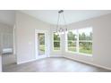 Bright dining area with large windows, modern lighting, and a door to the patio at 13098 Convent Garden Rd, Brooksville, FL 34614