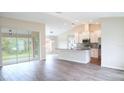 Open-concept kitchen featuring stainless steel appliances, granite countertops, and wood-look tile flooring at 13098 Convent Garden Rd, Brooksville, FL 34614